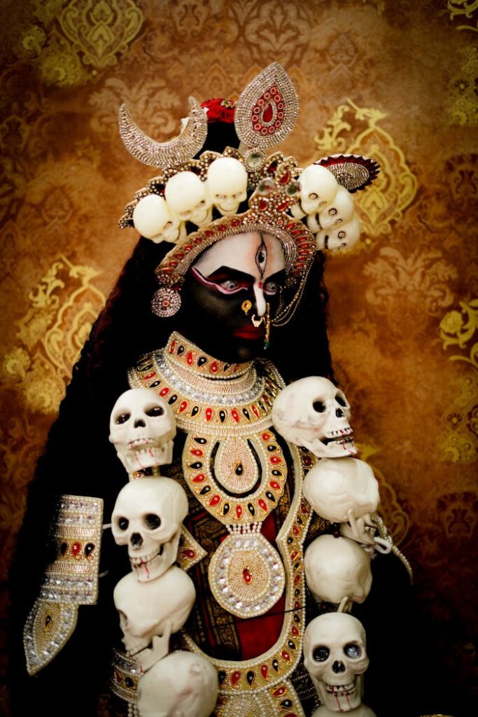A detailed depiction of a Goddess Kali statue adorned with skulls, intricate jewelry and elaborate headdress.